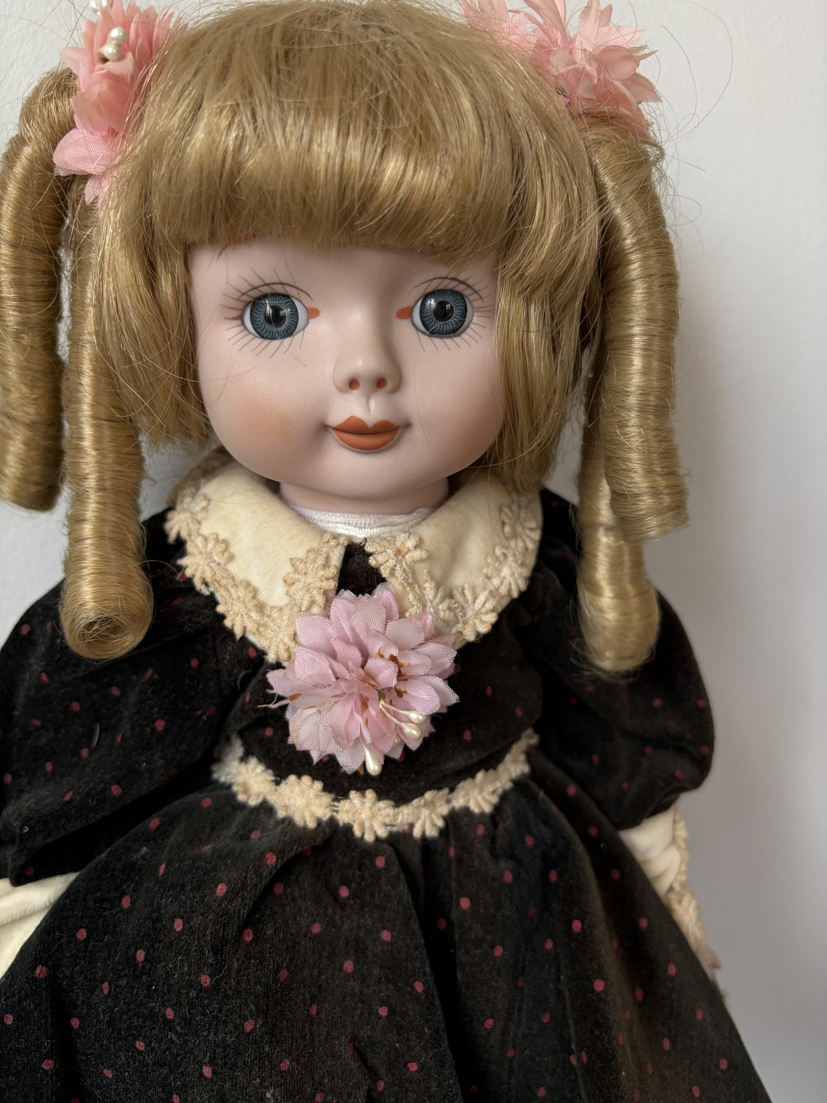 Vintage Porcelain Doll with Blonde Curls and Black Dress
